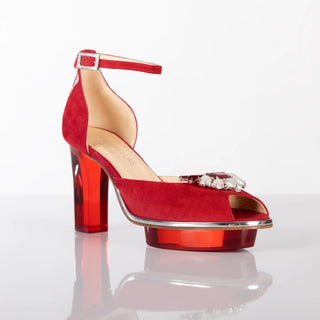 CINDERELLA'S RUBIS als Peeptoes Riemchenpumps in rot mit Brosche in pearl-rot. Ein zauberhafter Dirndlschuh als Peeptoes Riemchenpump von der Firma Cinderella’s by Marcela in rotem Wildleder mit eleganten Hirschgeweihstickerei sowie hochwertigem transparentem rotem Absatz und Plateau. Die Schuhe sind mit silbernen Accessoires verziert, und die Schnalle ist mit funkelnden Steinchen veredelt. Perfekt geeignet für Oktoberfest- oder gehobene Trachtenevents.