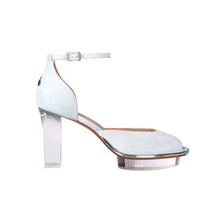 Ein zauberhafter Brautschuh als Peeptoe Riemchenpump von der Firma Cinderella’s by Marcela in silber-schimmerndem Rindsleder mit elegantem Nuss-Logo (als Inspiration aus dem Märchen drei Nüsse für Aschenbrödel) sowie hochwertigem transparenten Absatz und Plateau. Die Schuhe sind mit goldenen Accessoires verziert, und die Schnalle ist mit funkelnden Steinchen veredelt. Perfekt geeignet für Hochzeiten sowie alle gehobene Events.