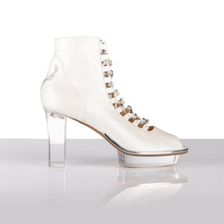 Ein zauberhafter Brautschuh als Peeptoe Stiefeletten  von der Firma Cinderella’s by Marcela in Ivory/Perlfarbe mit eleganten Hirschgeweihstickerei sowie hochwertigem transparentem Absatz und Plateau. Diese Dirndl-Stiefeletten sind mit silbernen Accessoires verziert. Perfekt geeignet für Hochzeiten im Dirndl-Stil sowie für Oktoberfest- oder Trachtenevents.