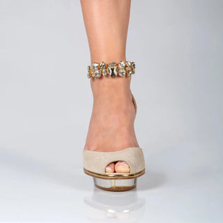 Ein zauberhafter Dirndlschuh oder Brautschuh als Peeptoe Riemchenpump von der Firma Cinderella’s by Marcela in gold-schimmernden Rindsleder mit elegantem Nuss-Logo (inspiriert aus dem Märchen 3 Nüsse für Aschenbrödel) sowie hochwertigem transparentem goldigem Absatz und Plateau. Die Schuhe sind mit goldenen Accessoires verziert, und die Schnalle ist mit funkelnden Steinchen veredelt. Perfekt geeignet für Abendmode, Galaabende, rote Teppiche oder Hochzeiten im Dirndl-Stil.