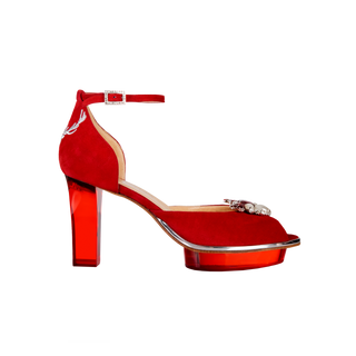 CINDERELLA'S RUBIS als Peeptoes Riemchenpumps in rot mit Brosche in pearl-rot. Ein zauberhafter Dirndlschuh als Peeptoes Riemchenpump von der Firma Cinderella’s by Marcela in rotem Wildleder mit eleganten Hirschgeweihstickerei sowie hochwertigem transparentem rotem Absatz und Plateau. Die Schuhe sind mit silbernen Accessoires verziert, und die Schnalle ist mit funkelnden Steinchen veredelt. Perfekt geeignet für Oktoberfest- oder gehobene Trachtenevents.