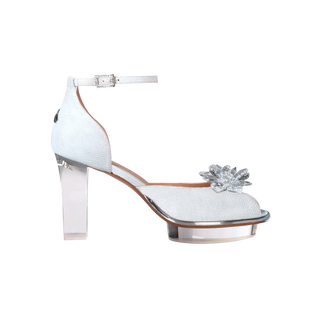 Ein zauberhafter Brautschuh als Peeptoe Riemchenpump von der Firma Cinderella’s by Marcela in silber-schimmerndem Rindsleder mit elegantem Nuss-Logo (als Inspiration aus dem Märchen drei Nüsse für Aschenbrödel) sowie hochwertigem transparenten Absatz und Plateau. Die Schuhe sind mit goldenen Accessoires verziert, und die Schnalle ist mit funkelnden Steinchen veredelt. Perfekt geeignet für Hochzeiten sowie alle gehobene Events.