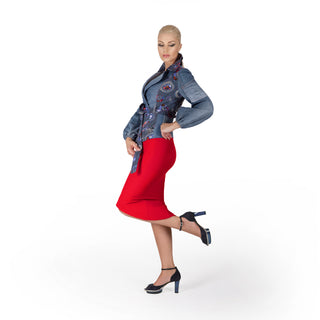 Eine schöne blonde Frau posiert in einem casual-eleganten Outfit bestehend aus rotem knielangen Rock und einer Denim-Jacke von Renatta Pruneda sowie magischen dunkelblauen CINDERELLAS Schuhen aus Wildleder mit hochwertigem transparenten Absatz und Plateau von Cinderellas by Marcela in einem Fotostudio.