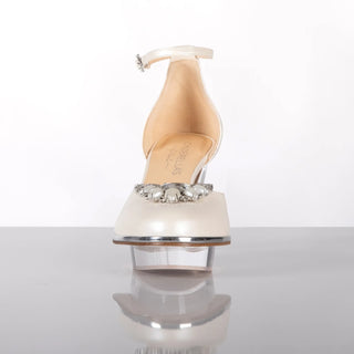 Ein zauberhafter Brautschuh als Closetoe Riemchenpump von der Firma Cinderella’s by Marcela in Ivory/Perlfarbe mit elegantem Nuss-Logo (als Inspiration aus dem Märchen drei Nüsse für Aschenbrödel) sowie hochwertigem transparenten Absatz und Plateau. Die Schuhe sind mit silbernen Accessoires verziert, und die Schnalle ist mit funkelnden Steinchen veredelt. Perfekt geeignet für Hochzeiten sowie alle gehobene Events.