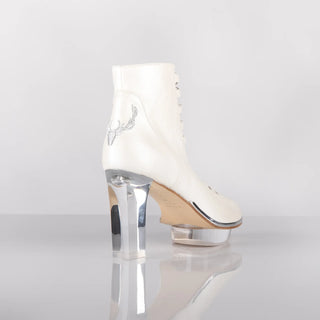 Ein zauberhafter Brautschuh als Peeptoe Stiefeletten  von der Firma Cinderella’s by Marcela in Ivory/Perlfarbe mit eleganten Hirschgeweihstickerei sowie hochwertigem transparentem Absatz und Plateau. Diese Dirndl-Stiefeletten sind mit silbernen Accessoires verziert. Perfekt geeignet für Hochzeiten im Dirndl-Stil sowie für Oktoberfest- oder Trachtenevents.