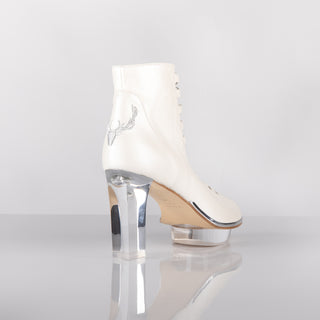 Ein zauberhafter Brautschuh als Peeptoe Stiefeletten  von der Firma Cinderella’s by Marcela in Ivory/Perlfarbe mit eleganten Hirschgeweihstickerei sowie hochwertigem transparentem Absatz und Plateau. Diese Dirndl-Stiefeletten sind mit silbernen Accessoires verziert. Perfekt geeignet für Hochzeiten im Dirndl-Stil sowie für Oktoberfest- oder Trachtenevents.