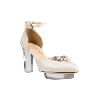 Ein zauberhafter Brautschuh als Closetoe Riemchenpump mit spitzer Schuhspitze von der Firma Cinderella’s by Marcela in Ivory/Perlfarbe mit elegantem Nuss-Logo (als Inspiration aus dem Märchen drei Nüsse für Aschenbrödel) sowie hochwertigem transparenten Absatz und Plateau. Die Schuhe sind mit silbernen Accessoires verziert, und die Schnalle ist mit funkelnden Steinchen veredelt. Perfekt geeignet für Hochzeiten sowie alle gehobene Events.